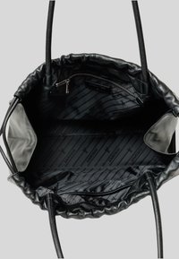 Borsa a spalla in pelle nera con chiusura a coulisse, caratterizzata da un interno con motivo e una tasca con cerniera su un lato. Texture liscia, forma strutturata.