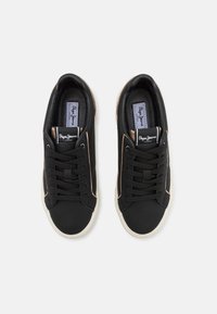 Sneaker nere con lacci, in tessuto superiore liscio, suola in gomma beige, accenti laterali a contrasto e etichetta con logo sulla linguetta.