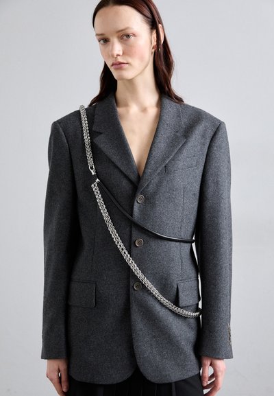 Blazer en mélange de laine gris avec un design croisé, featuring deux boutons, deux poches et une chaîne argentée sur le devant.