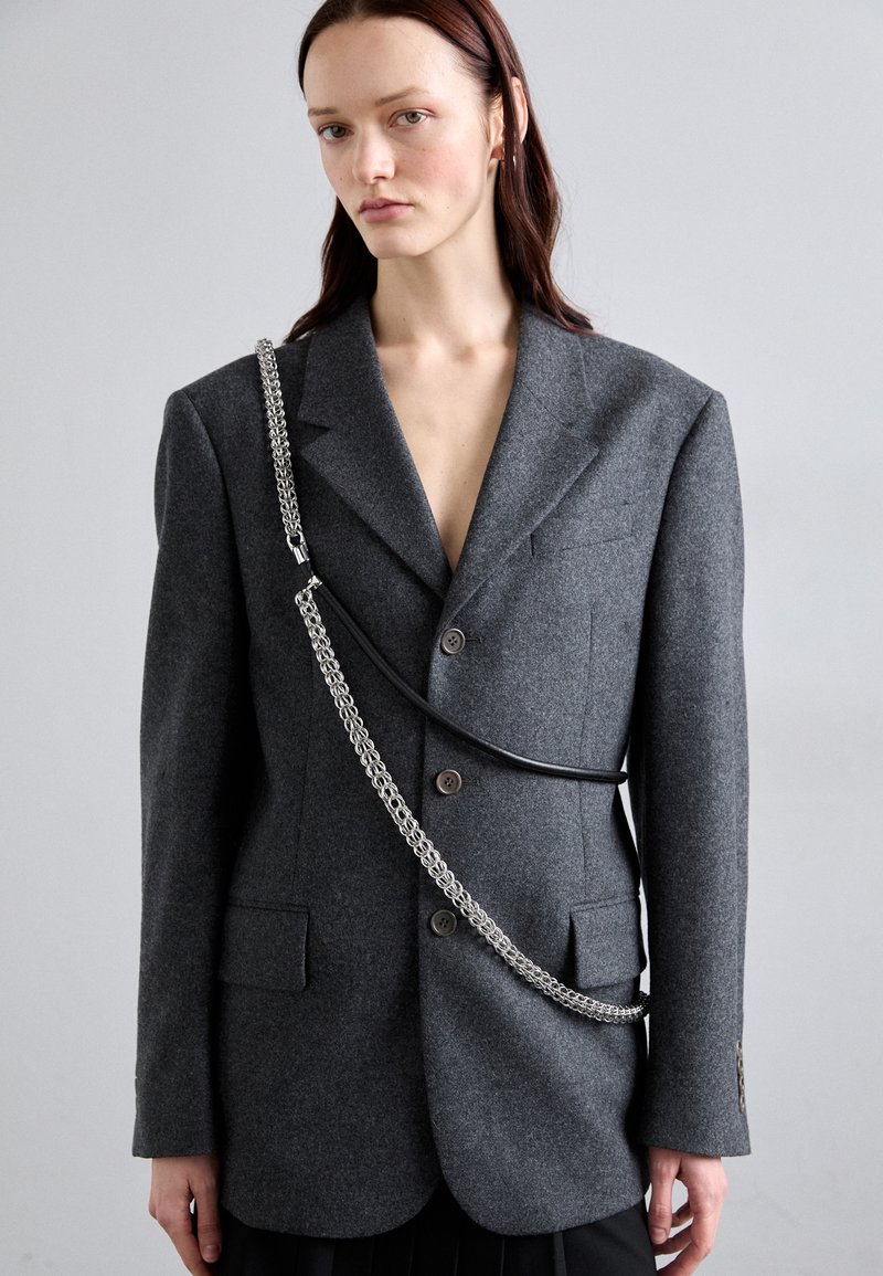 Gray wool blend blazer with a double-breasted design, featuring two buttons, two pockets, and a silver chain strap across the front.