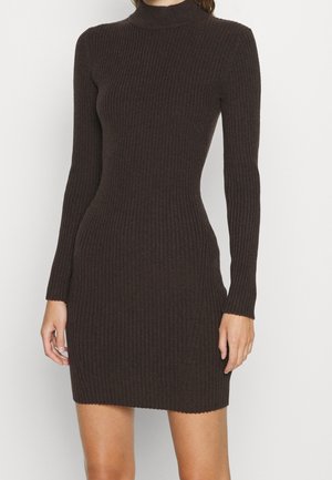 Robe ajustée en maille côtelée à manches longues, de couleur brun foncé avec un col montant, couvrant le haut du corps et s'étendant jusqu'à mi-cuisse.