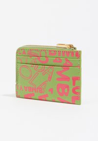 Zielony portfel o teksturowanej powierzchni, z odważnymi różowymi grafikami, zamek błyskawiczny i liczne sloty na karty. Złote metalowe akcenty dodają uroku.