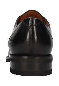 Scarpa di pelle nera con un design elegante, punta rotonda e tacco basso impilato. Presenta cuciture sottili e una finitura liscia.