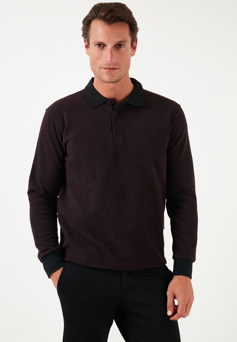 Mörk vinröd långärmad polo med svart krage och tre-knappsknäppning. Ribbad mudd och textil med struktur. Svarta byxor.
