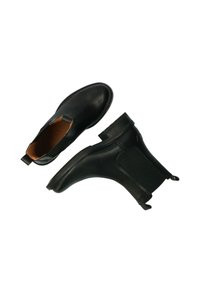 Botas Chelsea de cuero negro con paneles elásticos a los lados, puntera redonda y tiradores. Textura suave y tacones bajos en bloque. Diseño clásico.