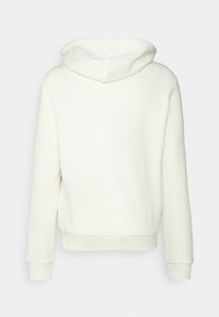 Sudadera blanca con una textura suave, mangas largas, capucha con cordón y puños y dobladillo acanalados. No hay diseño ni patrones visibles en la parte delantera.