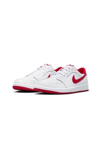 Scarpe da ginnastica bianche con accenti rossi, realizzate in pelle liscia. Le caratteristiche includono una punta perforata, lacci e suola in gomma con dettagli rossi.