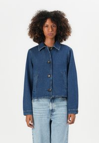 Temno moder denim jakna s ovratnikom, petimi sprednjimi gumbi, dvema stranskima žepoma in skrajšanim dizajnom. Ima gladko teksturo in sproščen kroj.