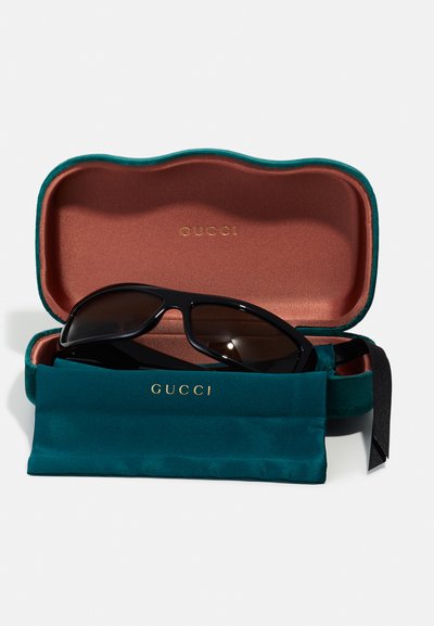 Gucci zonnebril in een zwart etui met een teal buitenkant en een bruine binnenkant. Inclusief een teal microvezel pouch met gouden branding.