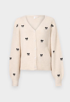Cardigan en tricot beige avec un col en V, orné de nœuds noirs brodés, à manches longues et avec des boutons blancs sur le devant.
