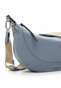Borsa in pelle blu a forma di mezzaluna, con una tracolla intrecciata beige, dettagli con zip nera e accenti in metallo.