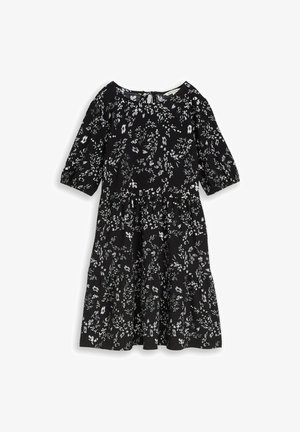 Black knee-length dress with white floral pattern, three-quarter puff sleeves, round neckline, and tiered skirt.