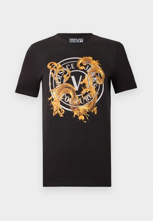 Schwarzes T-Shirt mit kurzen Ärmeln, verziert mit einem goldenen, kunstvollen Wirbelmuster und einem runden Logo mit der Aufschrift "Versace Jeans Couture" über der Brust.
