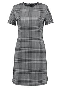 Lyhythihainen mekko, jossa on vartalonmyötäinen muoto, valmistettu mustavalkoisesta ruudullisesta kankaasta. Mekossa on pyöreä pääntie ja sivuhalkio.