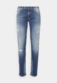 Jeans de mezclilla azul con un acabado desgastado, que presentan bolsillos frontales, una cremallera de botones y un efecto de desvanecimiento en el dobladillo y las rodillas.