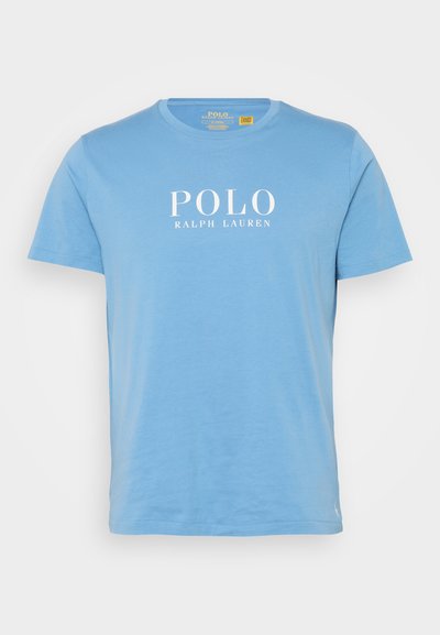 T-shirt de algodão azul-claro com decote redondo, apresentando o texto branco "POLO RALPH LAUREN" impresso na frente. Mangas curtas, ajuste casual.