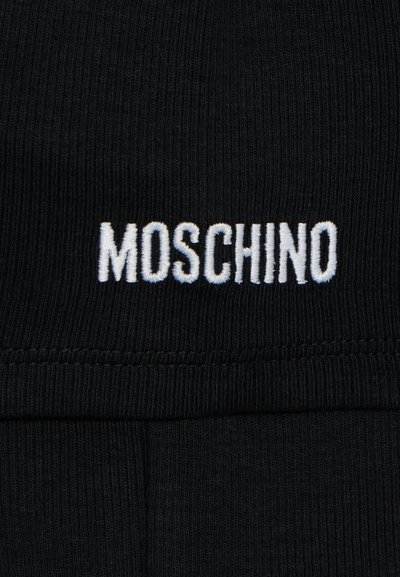 Tejido negro acanalado con el logo bordado en blanco "MOSCHINO". La textura es suave y elástica, con un diseño de ajuste ceñido.