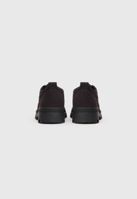 Sorte lærredssneakers med et lavprofil-design, rund hæl og tekstureret gummisål. Simpel stil med minimale detaljer.