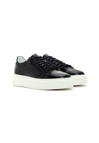 Sneaker in pelle nera con una tomaia texturizzata, suola piatta in gomma bianca e design con lacci. Presenta una cerniera laterale per una facile indossabilità.