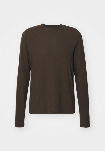 Maglietta a maniche lunghe con scollo rotondo di colore marrone scuro. Realizzata in un tessuto morbido e elasticizzato, con taglio dritto e cuciture minime. Senza pattern né dettagli.