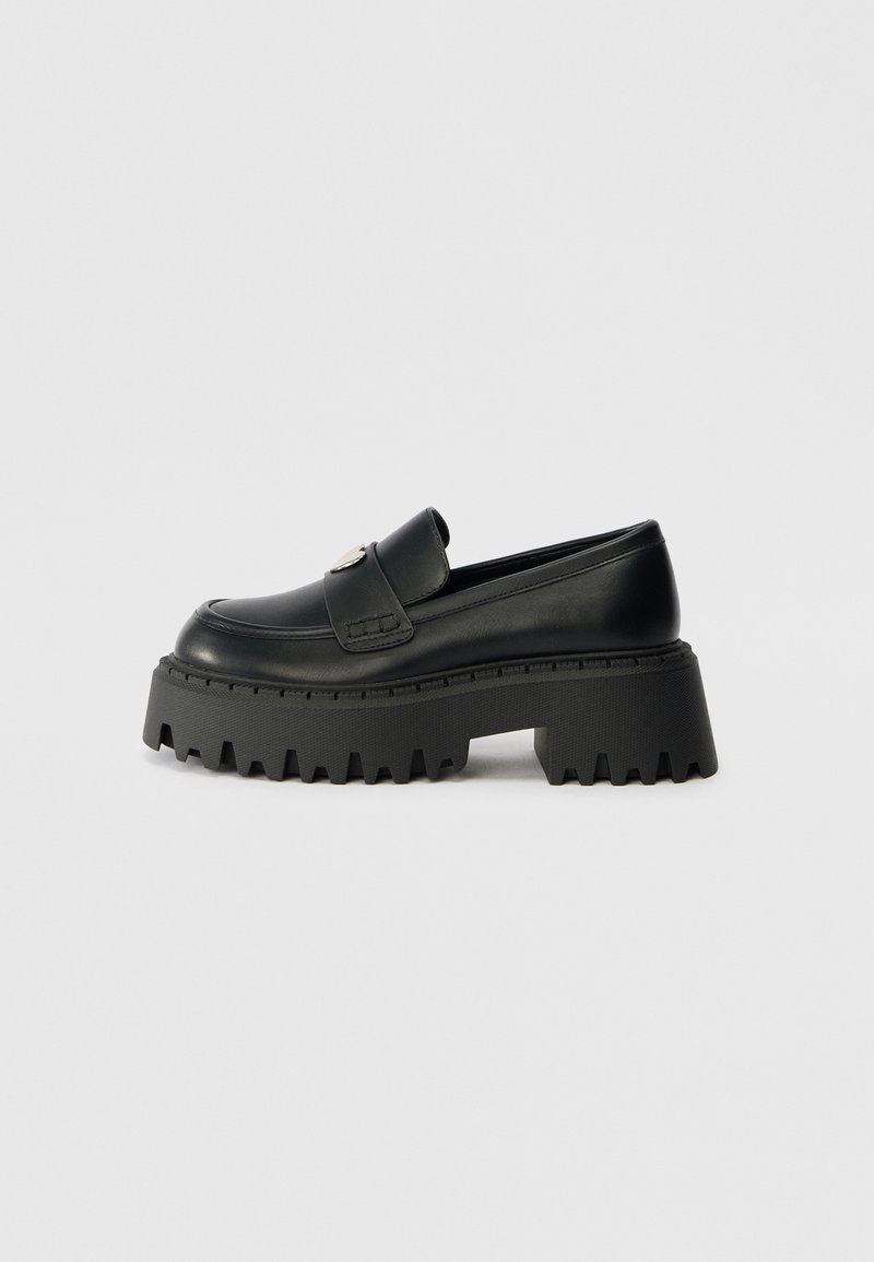 Black leather loafer with a thick, chunky rubber sole featuring a serrated edge and a single decorative hardware accent on the upper.