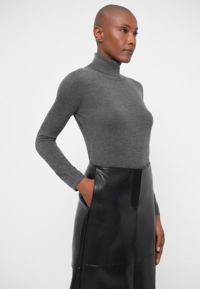 Szary golf z miękkiego materiału w połączeniu z czarną skórzaną spódnicą o wysokim stanie, z bocznymi kieszeniami i gładkim wykończeniem.