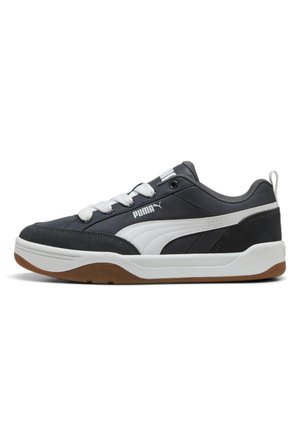Sneaker Puma in bianco e nero con lacci bianchi, suola in gomma e logo Puma sul lato e sulla linguetta, mostrata di profilo.