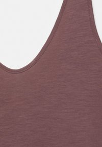 Gros plan d’un haut sans manches doux de couleur mauve avec un col arrondi et des coutures fines le long des bords.