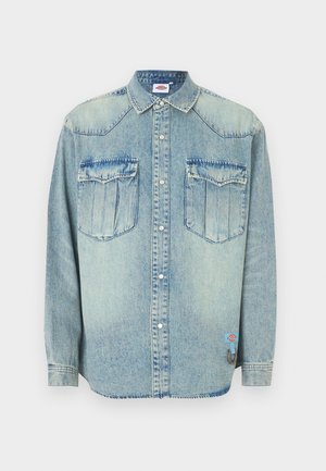 hele sinine teksapluus pikkade varrukatega, trukkidega sulgemine, terav krae, kaks rinnataskut ja brändi märk madalamal küljel.