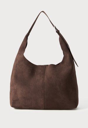 Bruine suède schoudertas met een slouchy vorm, enkele brede schouderriem en een naaddetail aan de voorkant. Gladde textuur, minimale hardware.