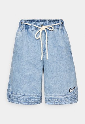 Denim shorts in light blue with an elastic waistband and drawstring. Features side pockets and a small black Nike logo on the hem.