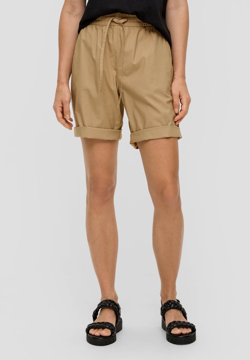 Beżowe szorty do kolan, wykonane z miękkiego, lekkiego materiału. Posiadają podwinięte mankiety i regulowany pas ze sznurkiem.