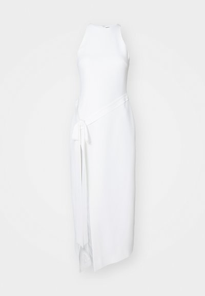 Balta be rankovių suknelė su aukštu apykakle, turinti asimetrinį kraštą, šoninius dirželius ir sklandžią tekstūrą.