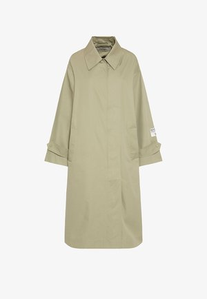 Beige trench coat with a button-up collar, long sleeves, side pockets, and a straight silhouette. Features a brand label on the sleeve.