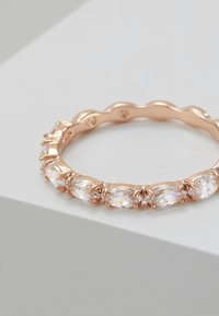 Roségoldring mit gewelltem Banddesign, das mehrere marquiseförmige, klare Steine in zarten Krappen zeigt. Glatte Textur und glänzende Oberfläche.