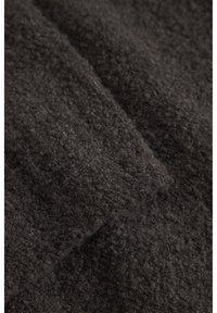 Sötétszürke, texturált anyag, puha, bolyhos felülettel, amely szálak keverékét tartalmazza, ami meleg és otthonos megjelenést kölcsönöz.