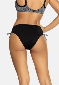 Czarne kąpielówki typu high-waisted z regulowanymi bocznymi sznurkami. Gładki materiał, minimalny krój i brak widocznych wzorów czy akcentów.