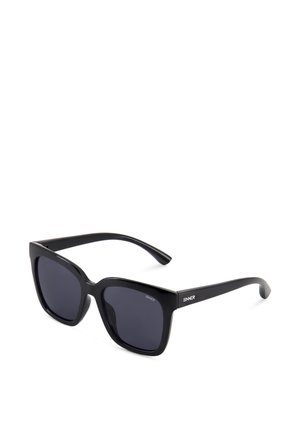 Czarne okulary przeciwsłoneczne z kwadratową oprawą i ciemnymi soczewkami oraz logo "SINNER" na zausznikach, prezentowane na białym tle.