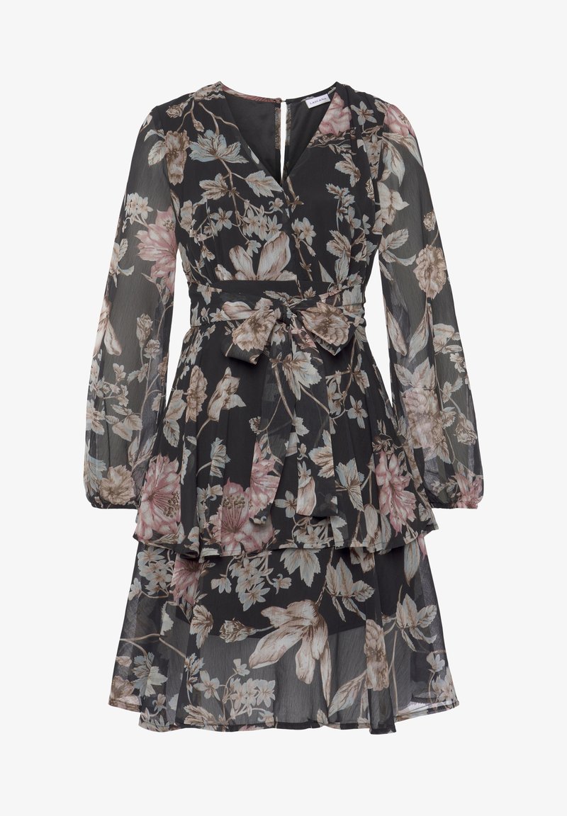 Robe longue noire transparente à manches longues, jupe à volants, imprimé floral dans des tons rose pâle et beige, col en V et ceinture en tissu assortie nouée à la taille.