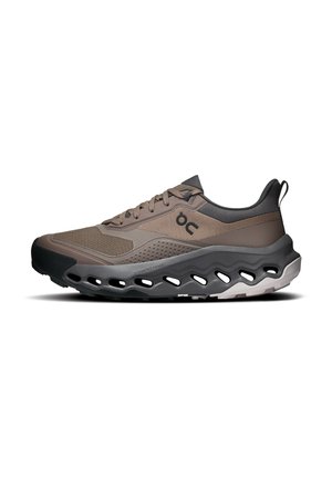 Baskets de sport marron clair et noir avec dessus en mesh et synthétique, fermeture à lacets à l’avant et semelle épaisse rembourrée avec détails découpés sur les côtés.