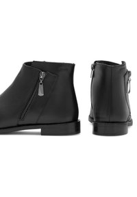 Czarne skórzane botki za kostkę o smukłym fasonie, z bocznymi suwakami i niskimi blokowymi obcasami. Gładka tekstura i minimalistyczne akcenty.