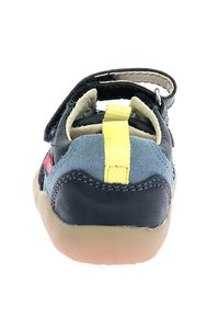 Sandali per bambini con tomaia in suede blu e pelle nera, dettaglio della cinghia gialla, cinturino alla caviglia regolabile e suola in gomma color cuoio.