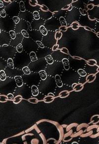 Tessuto nero con un motivo a catena ripetuto, accentuato da dettagli rosa chiaro e scuro. Texture liscia con una leggera lucentezza, che crea profondità.