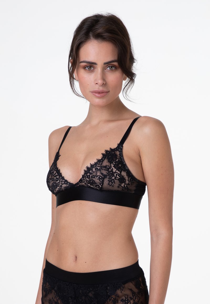 Bralette in pizzo nero con forma triangolare, tessuto trasparente, bordi a scallop e una fascia sottostante in satin liscio. Spalline semplici e regolabili.
