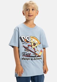 Modrá bavlnená tričko s grafikou postavy pizzi na skateboarde a textom "DC Shoe Co. HOT SLICE vždy doručuje."