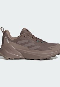 Brauner Wanderschuh aus atmungsaktivem Material, mit auffälligem Drei-Streifen-Design, strukturiertem Obermaterial und robuster Gummisohle mit Traktionsstollen.