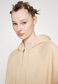 Obey Clothing REESE RELAXED FIT HOODED VEST - Μπλουζάκι με στάμπα - oat milk