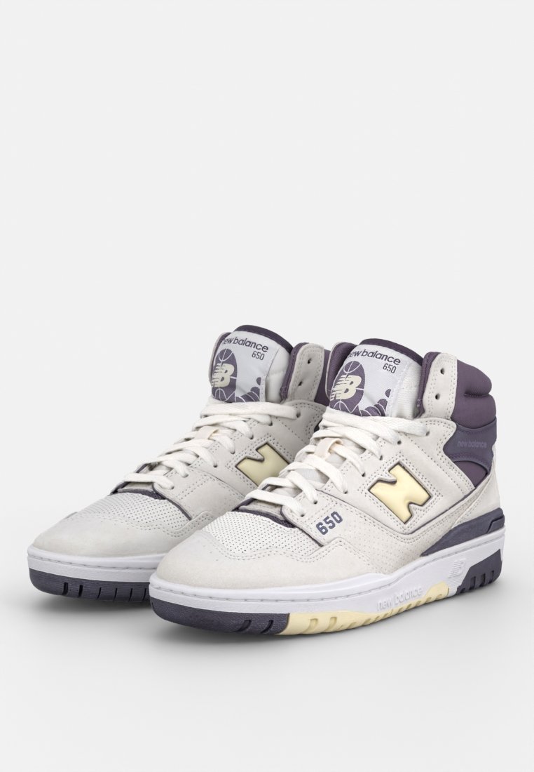 Sneaker alte in pelle e suede bianca, con accenti viola, pannelli in rete e un logo retrò. Collare imbottito notevole e suola testurizzata.