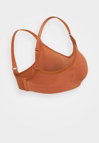 Sutiã desportivo de cor bronze com alças ajustáveis, apresentando uma textura suave, design sem costuras e múltiplos fechos de gancho e olho nas costas.