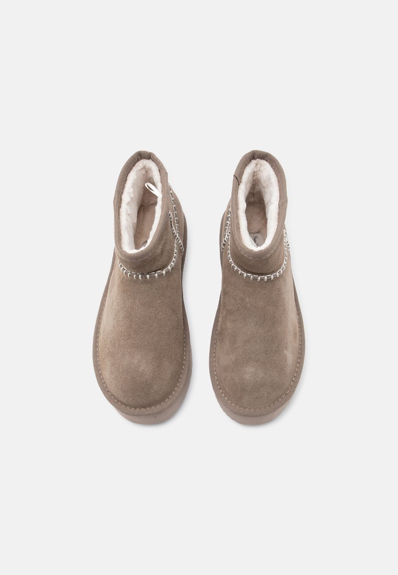 Braune Wildleder-Stiefeletten mit einer weichen, weißen Innenausstattung. Verfügt über eine gestickte Akzentuierung entlang des Kragens und eine Schlaufe zum einfachen Anziehen.